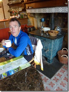 Steve having hot chocolate in front of old stove